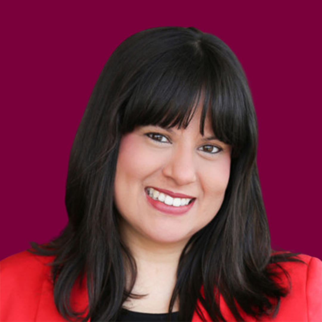 Portrait of Plezzie Ramirez, a smiling Hispanic woman with dark hair and a wide smile, wearing a red blazer.