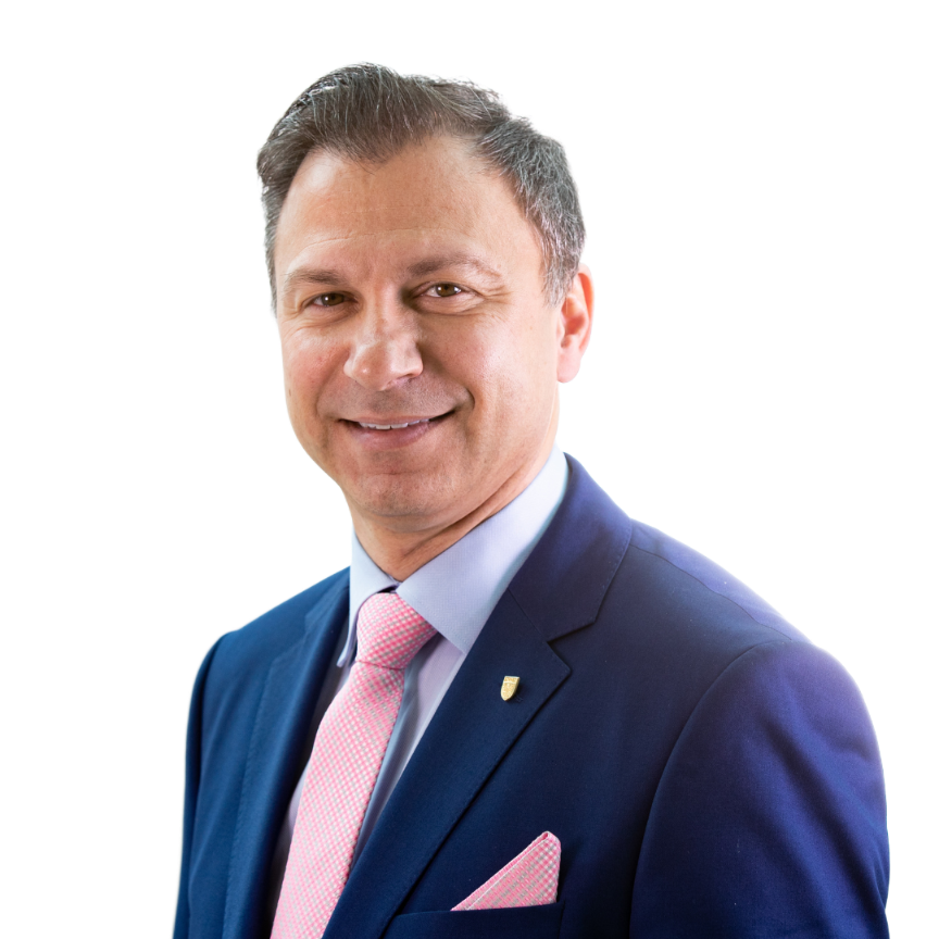 Headshot of Nick Bontis, a smiling man with light brown hair, wearing a navy suit, pink tie, and a gold lapel pin.