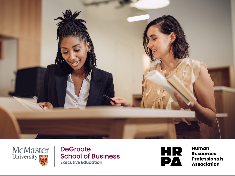 Two HR professionals reviewing study materials together.