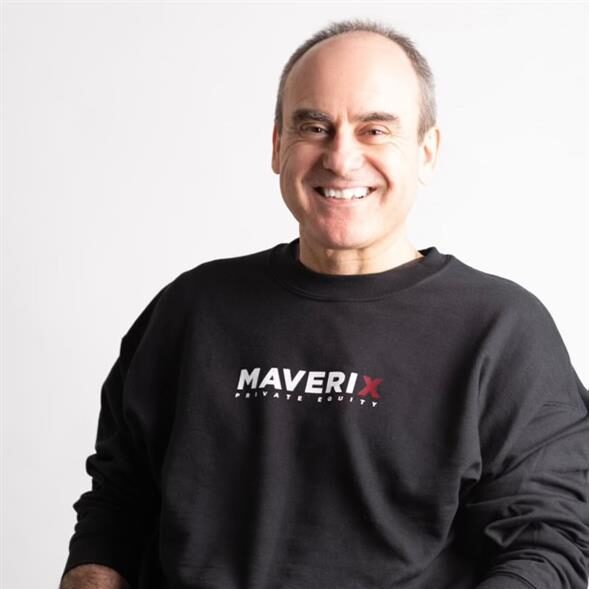Headshot of John Ruffolo, wearing a black Maverix sweatshirt and seated in a wheelchair.